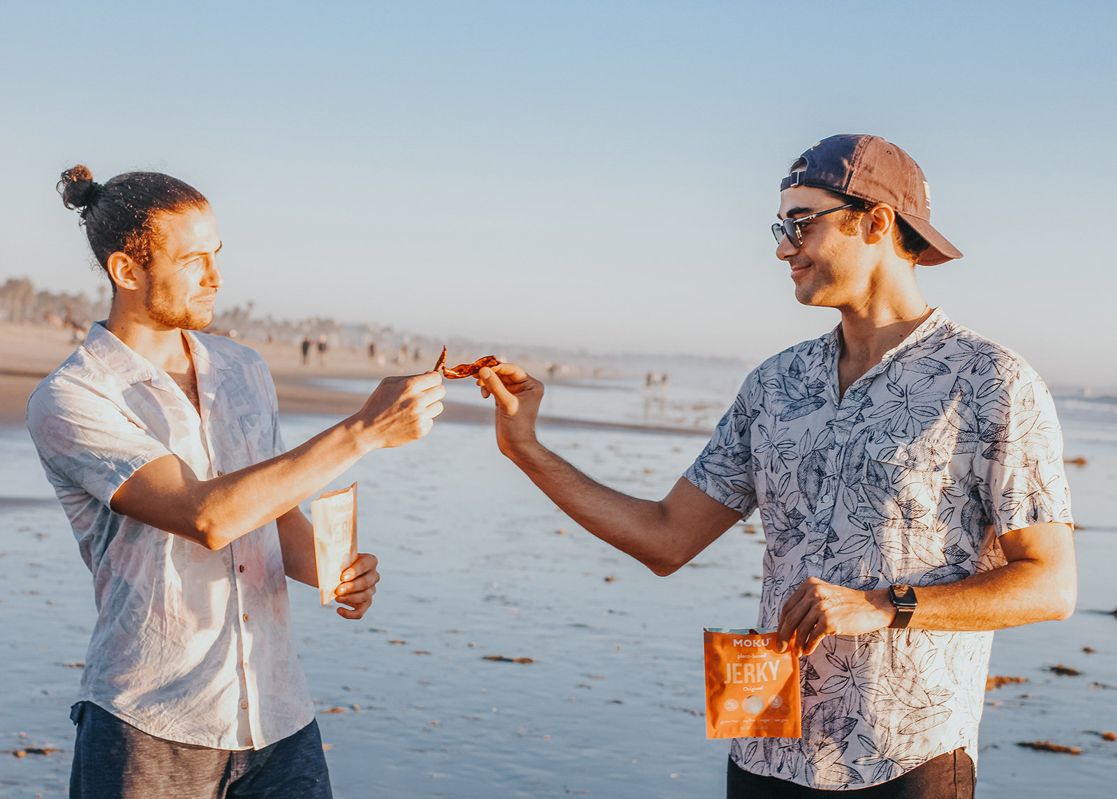 two guys sharing a bag of moku